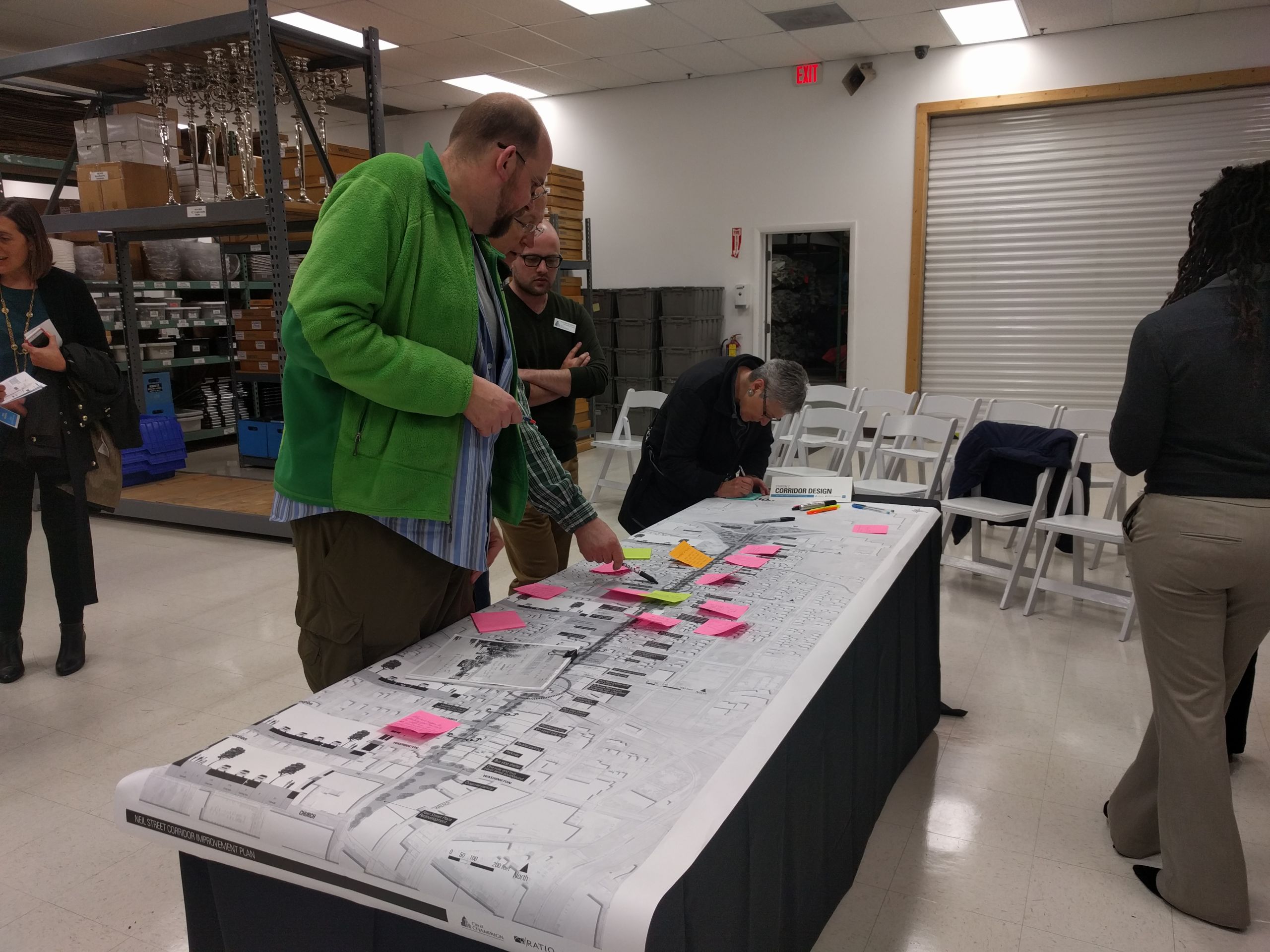 A group of people surround a table with a map and post it notes.