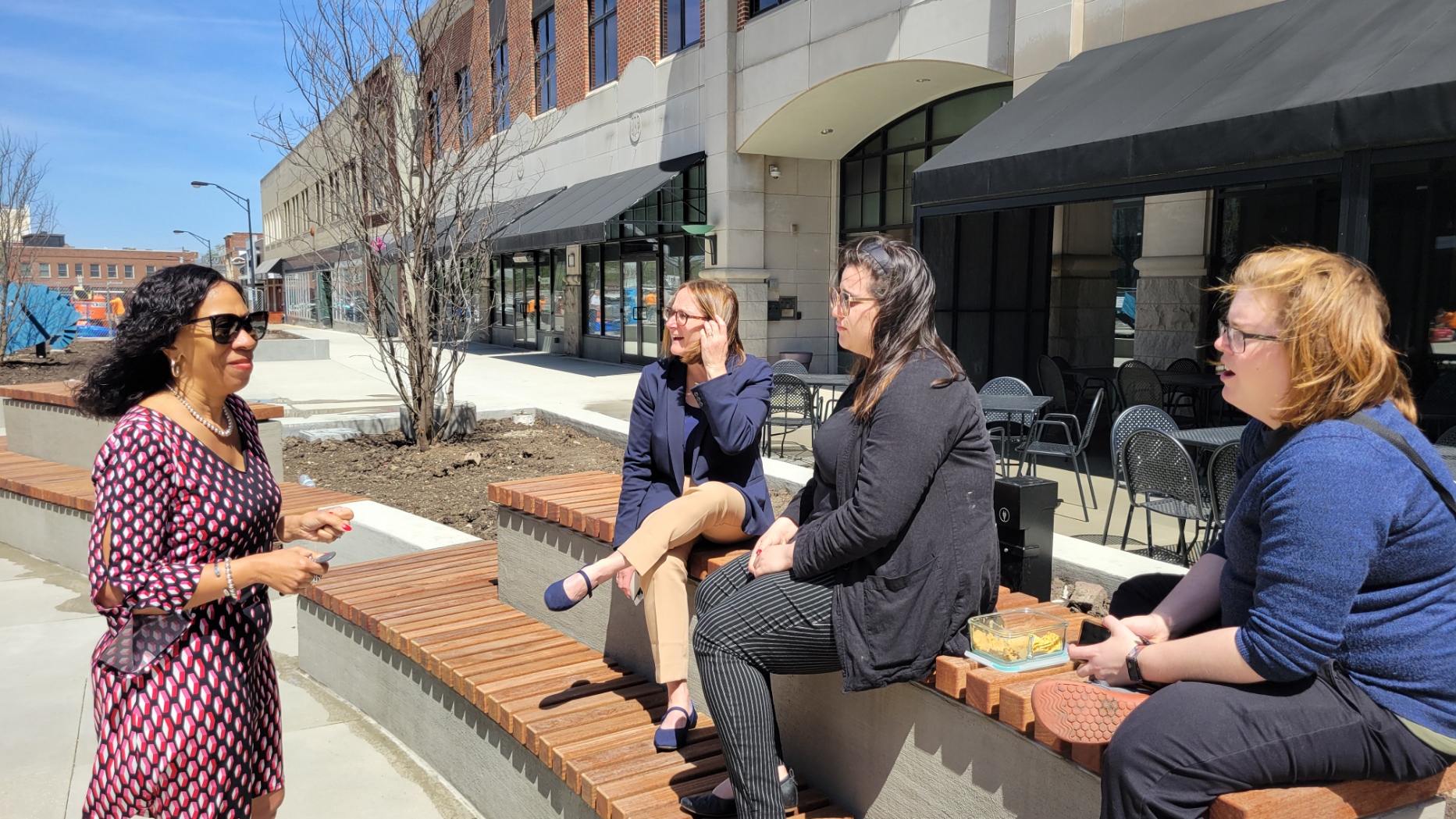 Members from the Planning department use the bench seating in the plaza while chatting with the City Manager and Mayor